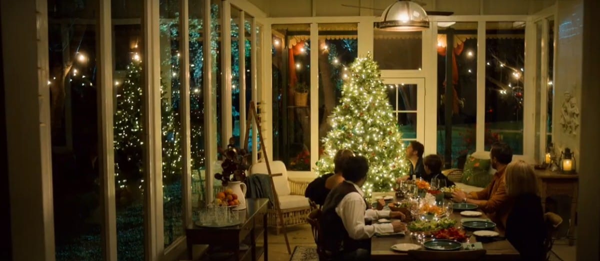 Family at the table looking at the Christmas tree lights
