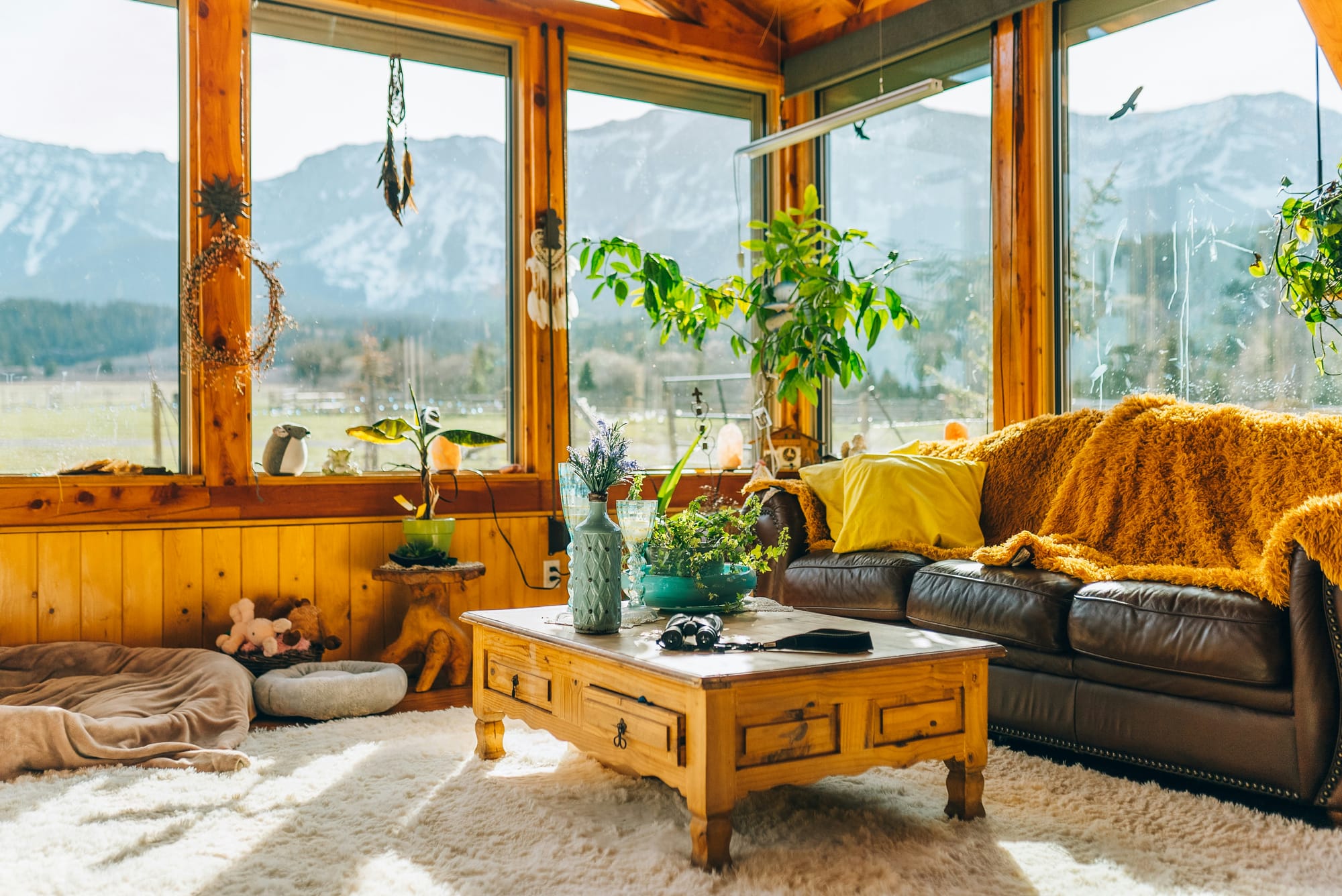 Country styled lounge room with coffee table, leather sofa, throws and cushions